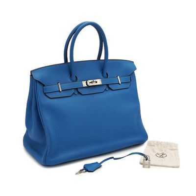 a blue leather handbag with a key in it