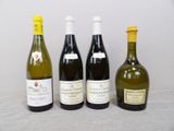 four bottles of wine are lined up on a table