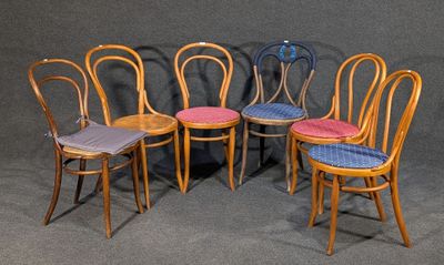 quatre chaises en bois sont alignées sur un fond gris