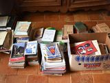 une boîte remplie de livres sur le sol, à côté d'une commode