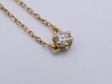 a gold necklace with a single diamond on a chain