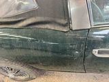 a green car with a black cover on it
