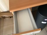 a small kitchen with a stove, microwave, and a trash can