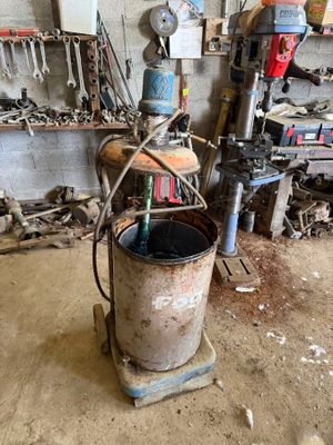 a metal bucket sitting on top of a table in a garage