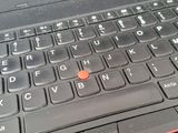 a close up of a laptop with a red button on the keyboard