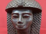 a close up of a sculpture of a woman ' s head on a red surface