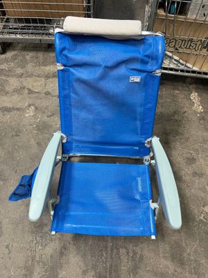 une chaise de plage bleue avec un rouleau de tissu posé sur le dossier