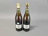 two bottles of wine sitting next to each other on a table