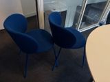 deux chaises bleues placées l'une à côté de l'autre dans une pièce