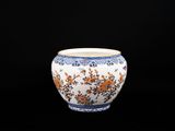 un vase blanc orné de fleurs orange sur fond noir