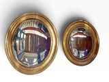 two mirrors that are on the wall next to each other