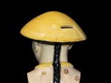 a yellow and black vase with a yellow hat on it