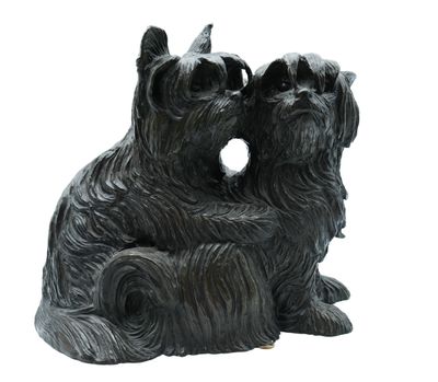 statue représentant deux chiens assis sur une souche d'arbre percée d'un trou au milieu