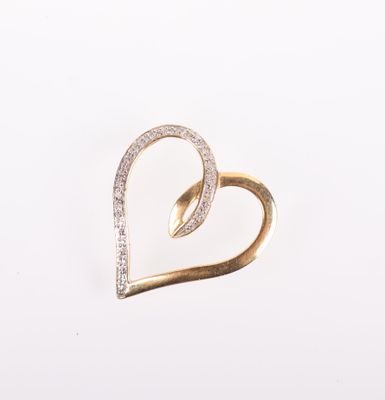 un gros plan sur une broche en or en forme de cœur, sertie de diamants