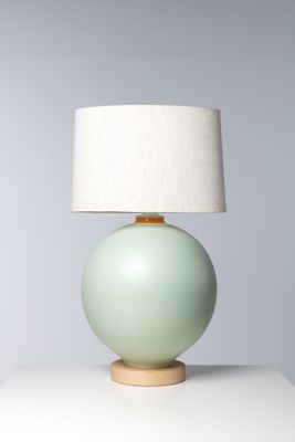 une lampe verte surmontée d'un abat-jour blanc
