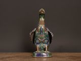 a close up of a bird figurine on a wooden table