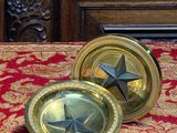 une assiette en or ornée d'une étoile, posée sur une table rouge