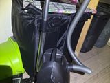 a green vacuum and a black bag on the floor