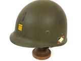an old military helmet on a wooden base on a white background