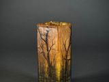 an image of a tall glass vase with trees in the background