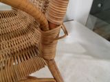 une chaise en osier avec une assise et un accoudoir en bois