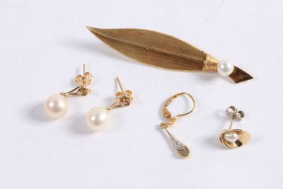 trois paires de boucles d'oreilles et une feuille sur un fond blanc