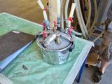 une petite table sur laquelle se trouve une casserole en métal, dans un garage