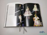 an open book with a picture of a fashion show on it