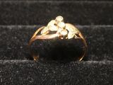 une bague en or sur laquelle est représenté un singe, sur un fond noir