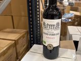 une bouteille de vin posée sur des cartons dans un entrepôt