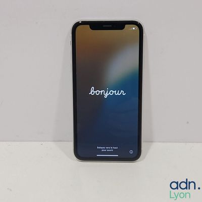 un iPhone avec le mot « bonjou » affiché à l'écran, posé sur une table