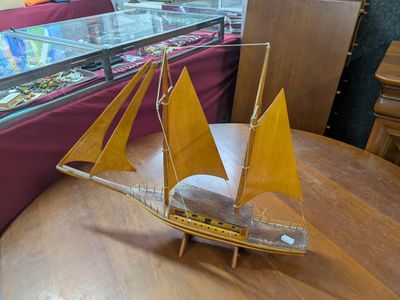 une maquette en bois d'un voilier posée sur une table