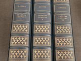trois livres sont alignés sur une table