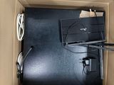 a laptop in a box with wires and cords in it