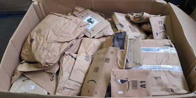 une boîte en carton remplie de boîtes et de colis posée par terre