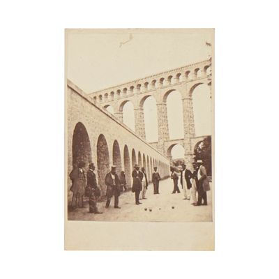de nombreuses personnes debout devant un mur de pierre