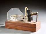 une petite maquette de machine à vapeur posée sur un socle en bois