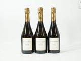 trois bouteilles de vin posées sur une table l'une à côté de l'autre