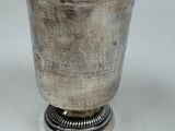 a silver cup that is sitting on top of a table