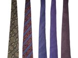 four different colored ties are lined up on a white surface