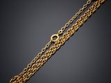 a gold chain bracelet with an oval clasp on a black background