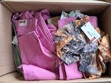 a cardboard box filled with assorted clothing and a price tag