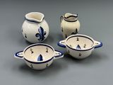 four pieces of blue and white pottery sitting on top of a table