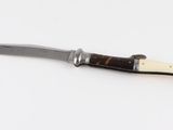 a knife that is laying on a white surface