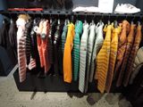 many jackets hanging on a rack in a store