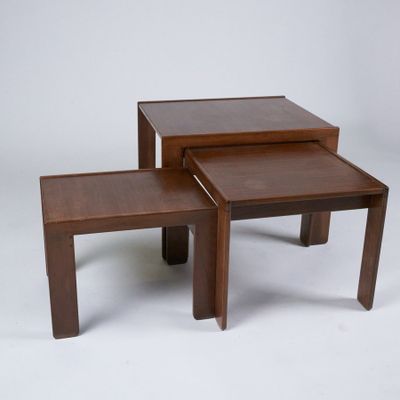 two small tables with one sitting on top of it and one sitting on the ground