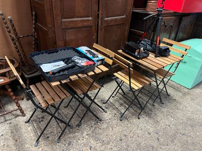 une table et des chaises placées à l'extérieur, devant une porte