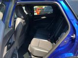a blue car with the back seats down and the door open