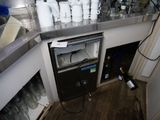 un petit réfrigérateur dans un coin de la cuisine, sur lequel sont posées de nombreuses tasses