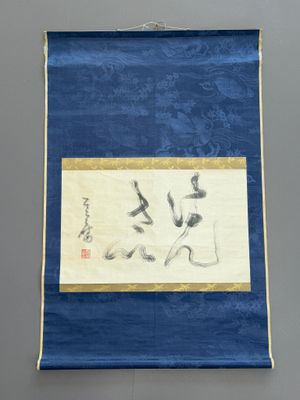 a blue and white painting hanging on a wall next to a wall